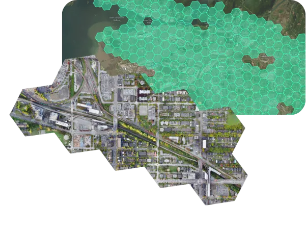 Aerial map showing a section of Vancouver city with roadways and buildings, overlaid partially by a hexagonal green grid covering coastal and land areas.