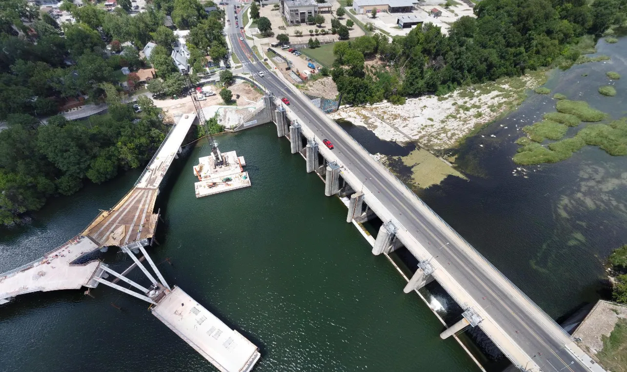 Aerial view of a bridge over a river with ongoing construction on a new adjacent bridge.