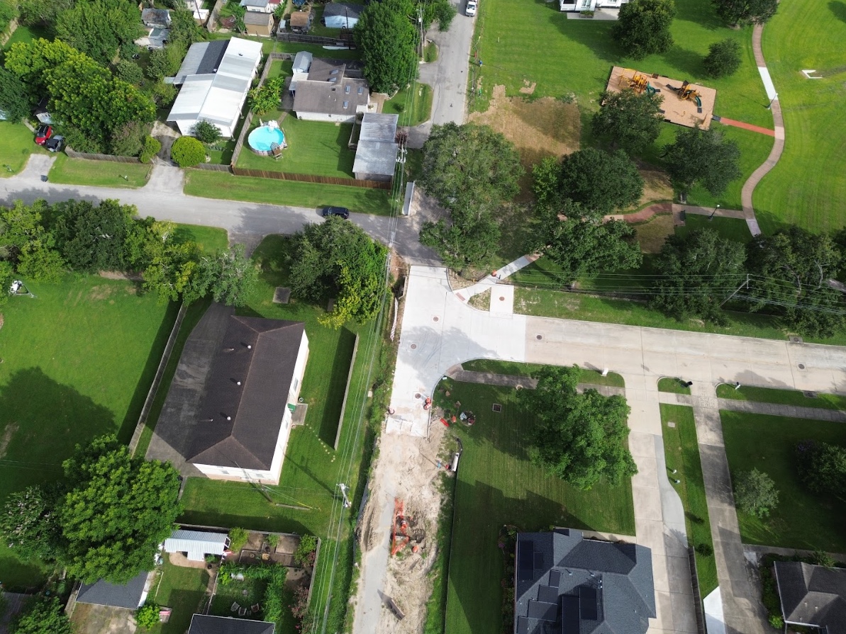 Aerial view of a mostly empty parking lot near a large circular arena building.