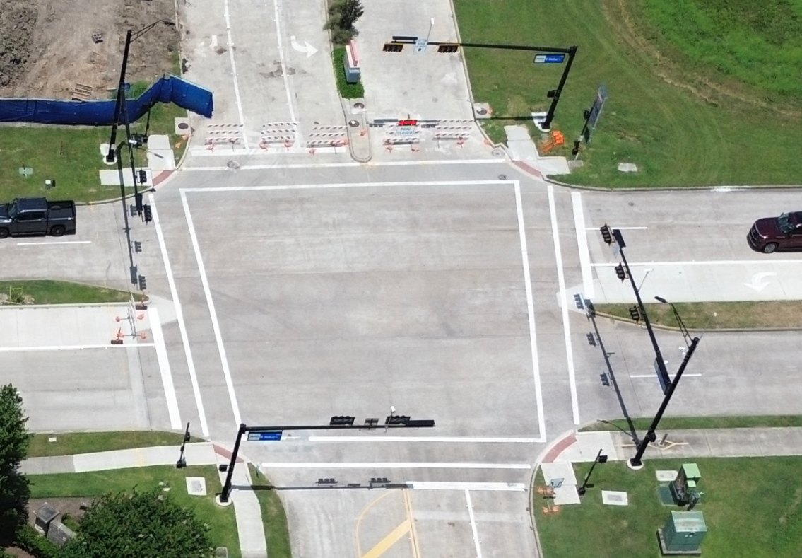 Nadir static image: a straight-down drone photo of the same intersection, showing crosswalks, signal poles and barricades.
