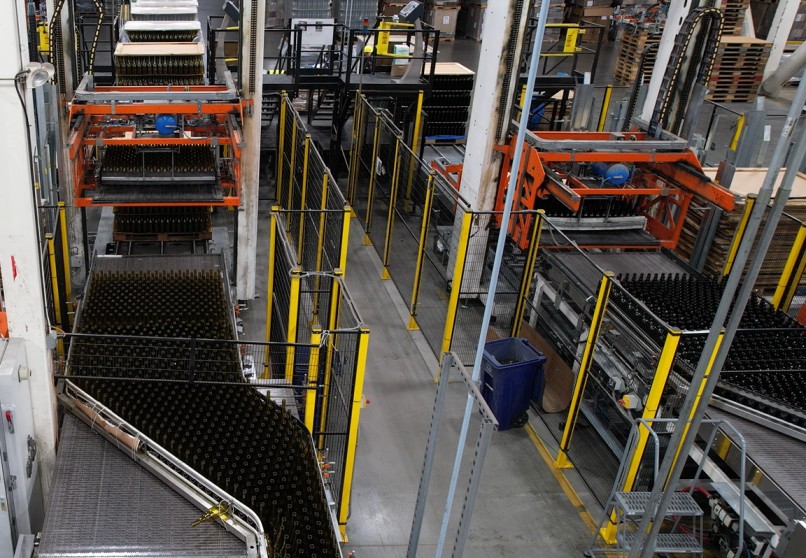 Manufacturing logistics facility with automated conveyors and warehousing systems moving bottles for distribution.
