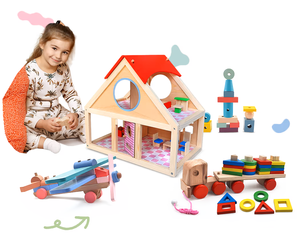 Smiling toddler girl with light brown hair sitting near wooden toys including a dollhouse, airplane, toy train, and colorful stacking blocks.