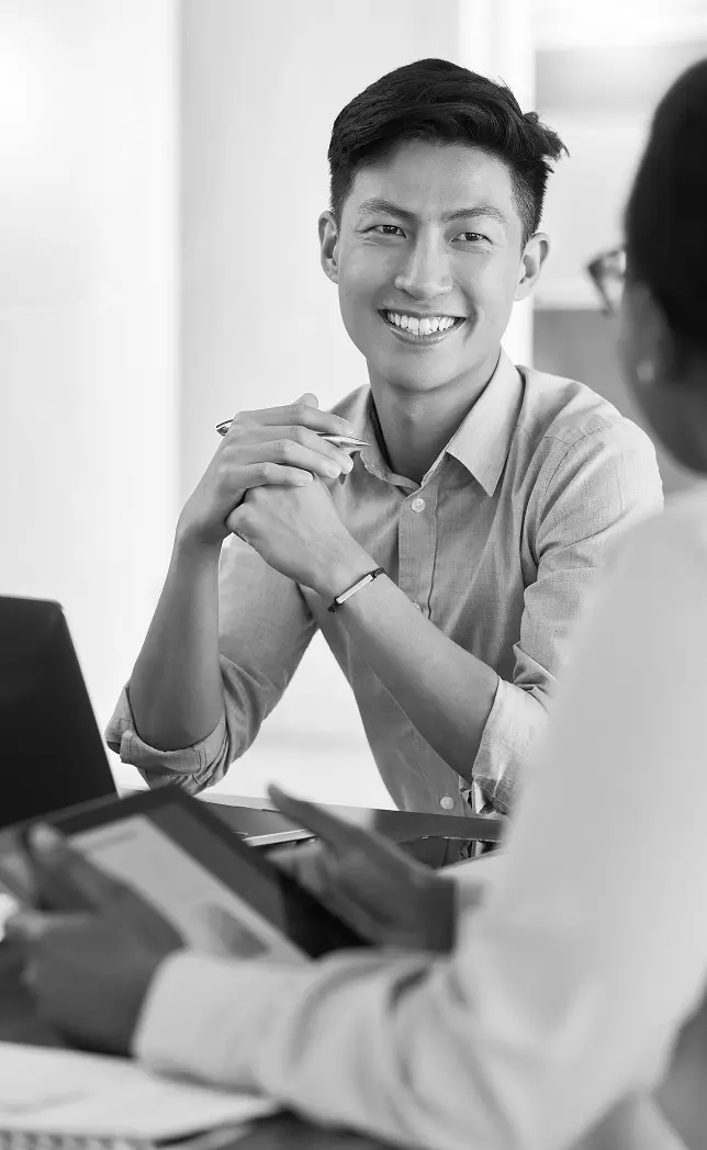 Man sitting at meeting with hands clasped