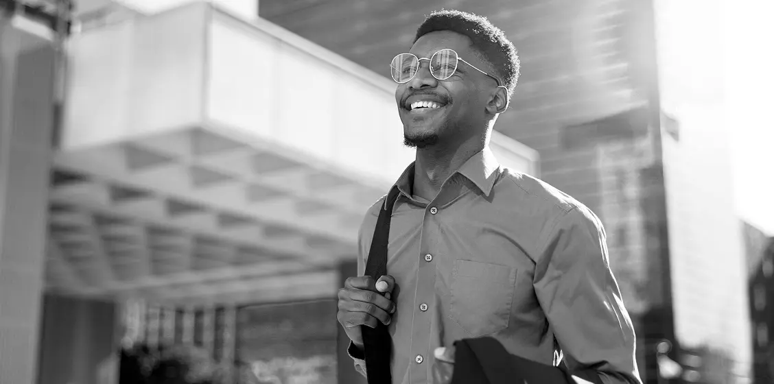 Man walking w/ backpack and suit coat to work