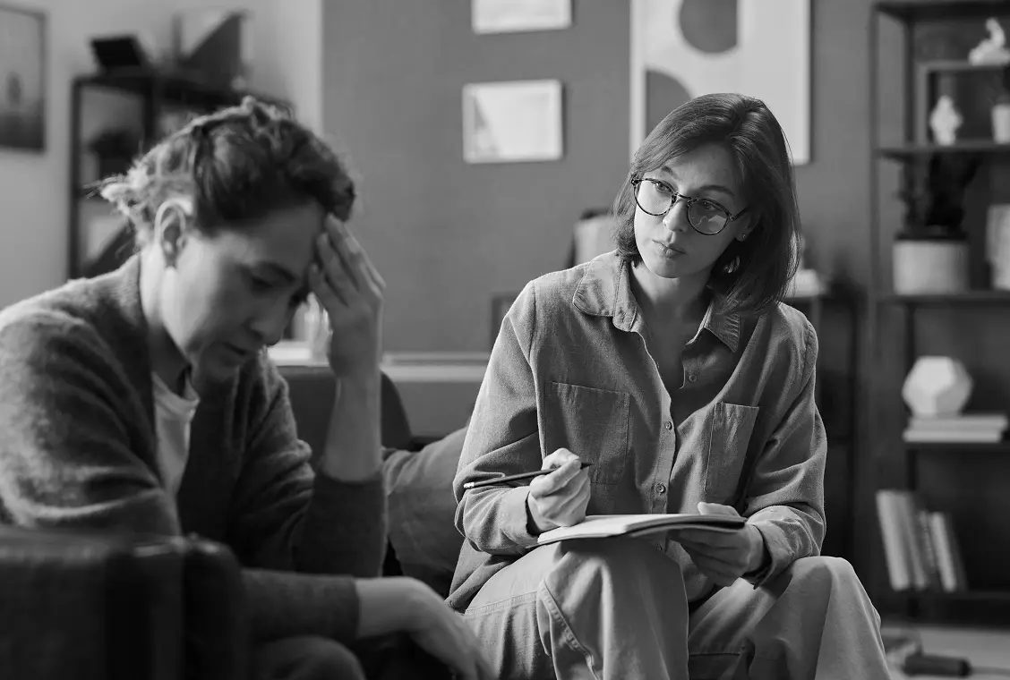 Woman recieving therapy w/ hand massaging temple