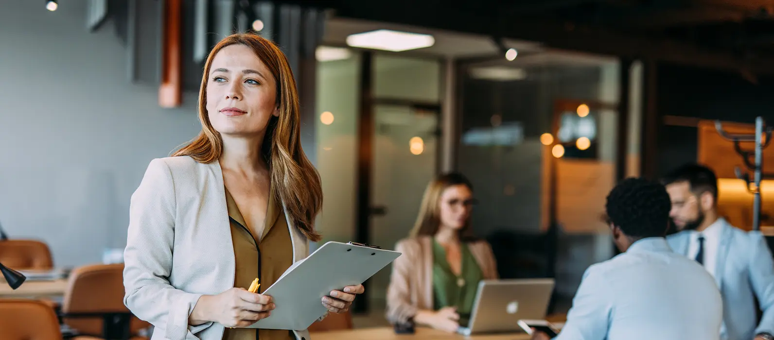 Woman looking up from clipboard in office