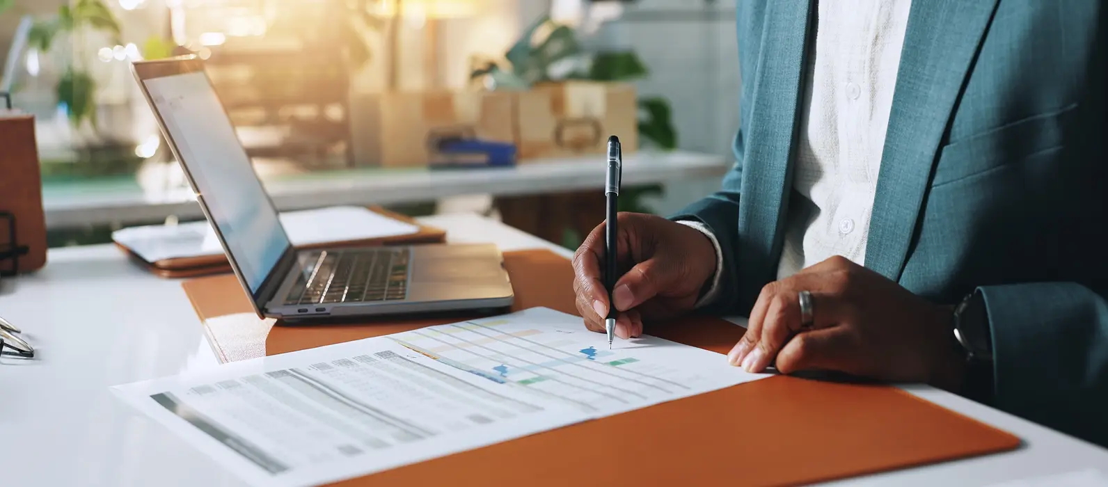 man writing on report by table