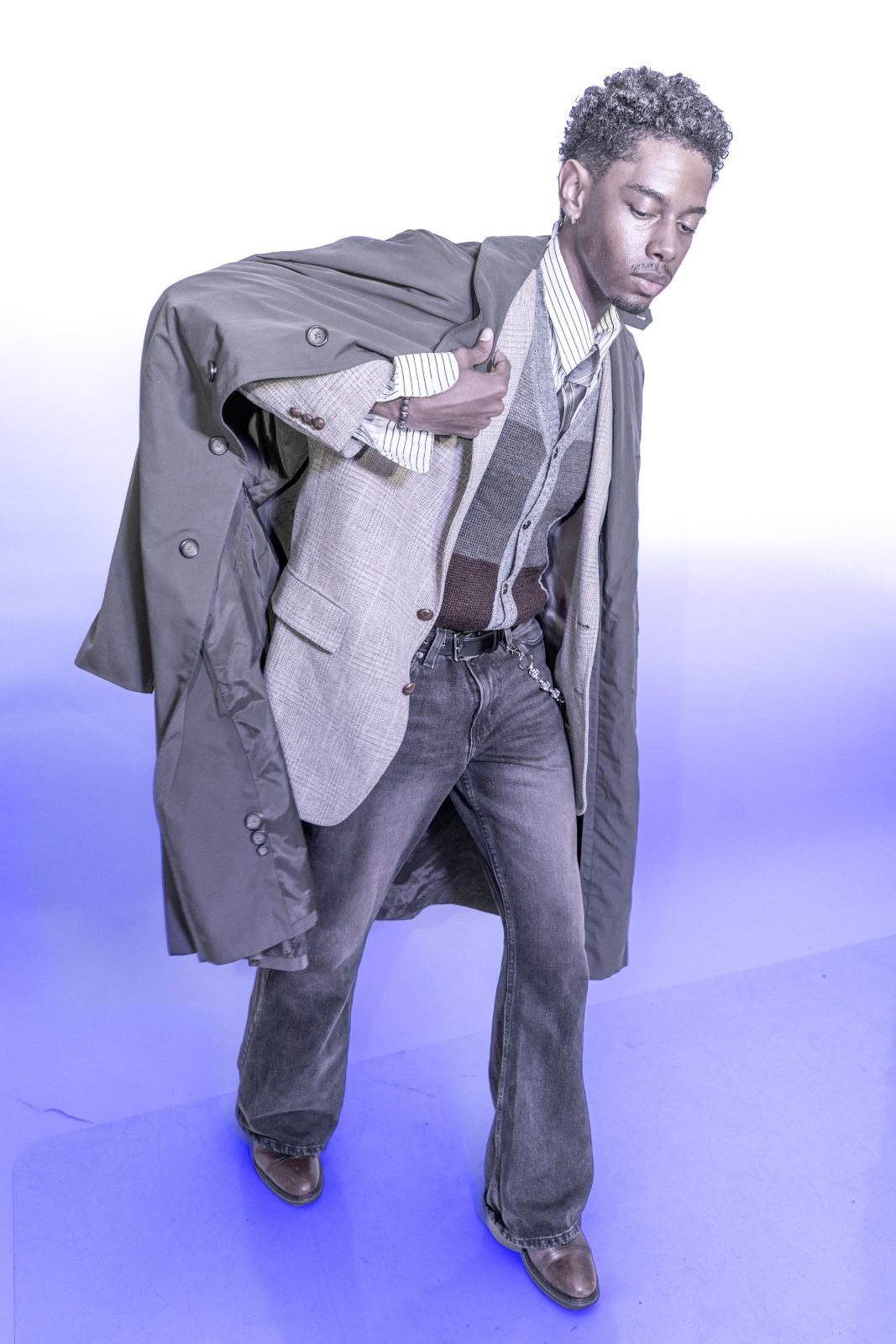 Studio menswear editorial in layered vintage tailoring under coloured gels