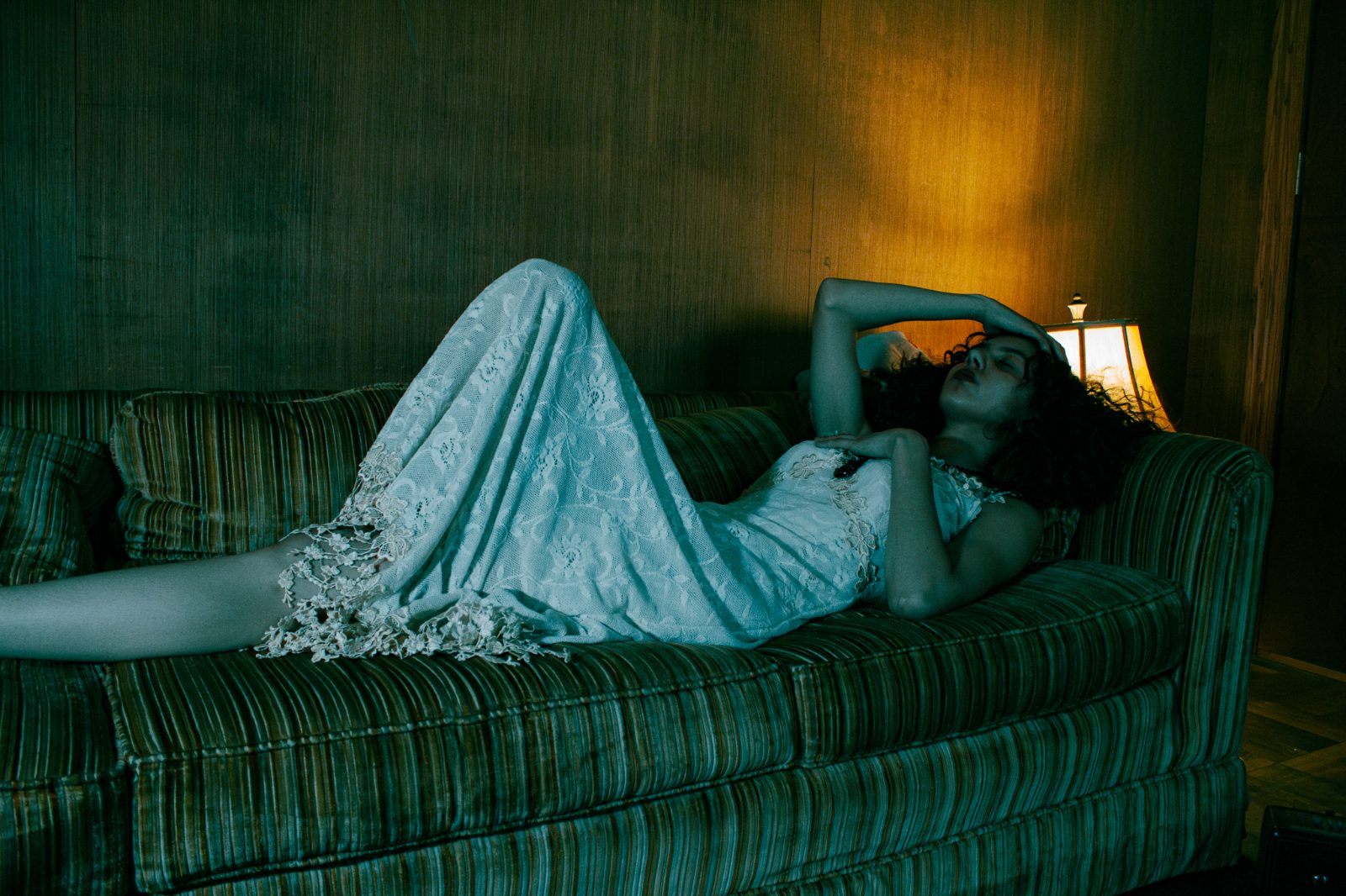 Retro-interior editorial frame, tungsten lamp light and teal shadow