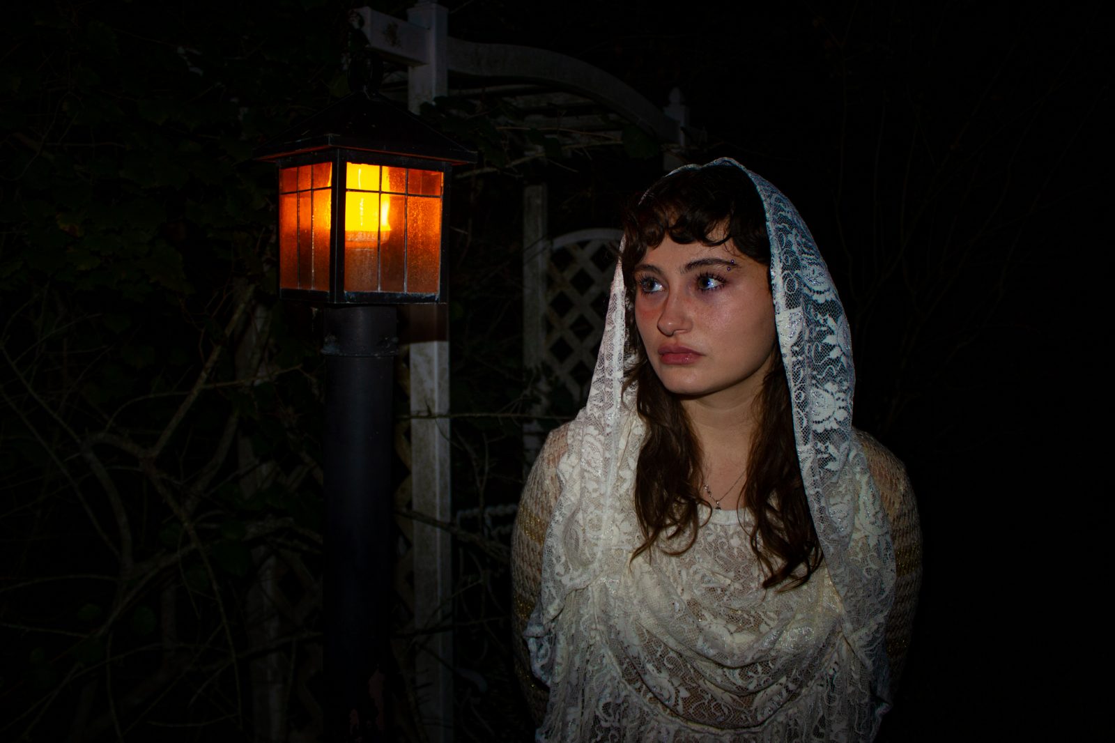 Night editorial in a lace veil, lit by a single lantern