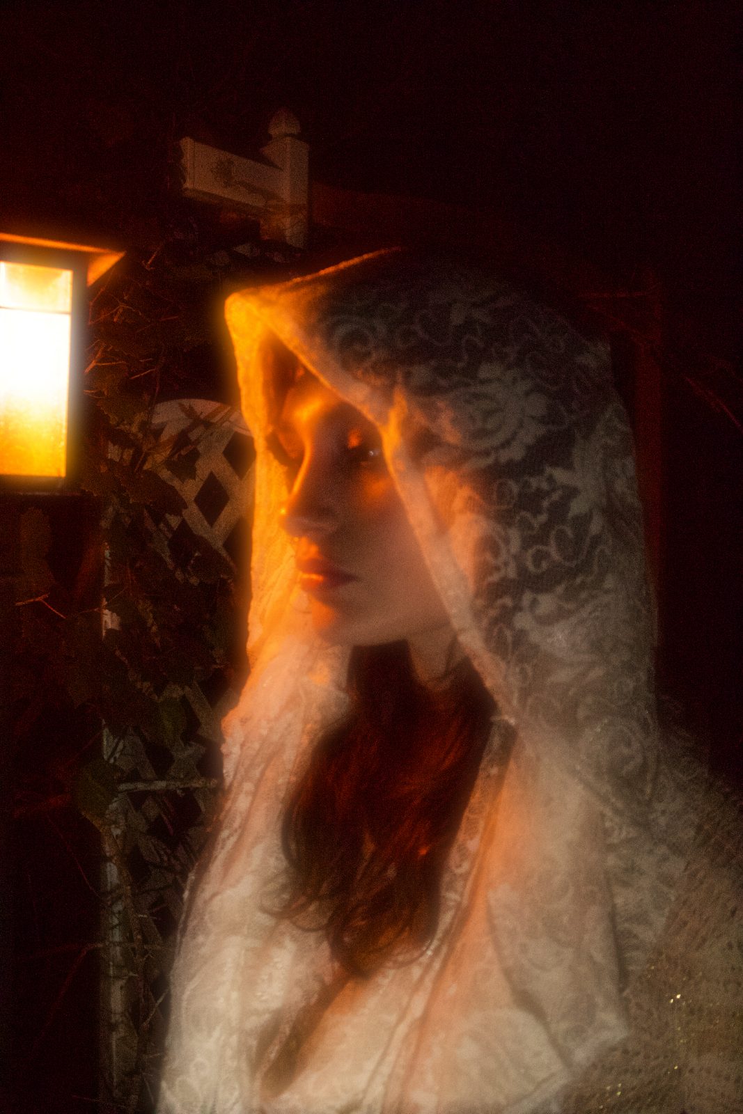Night editorial in a lace veil, lit by a single lantern