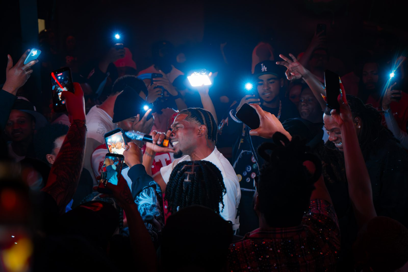 Crowd holding phone lights up at a packed venue
