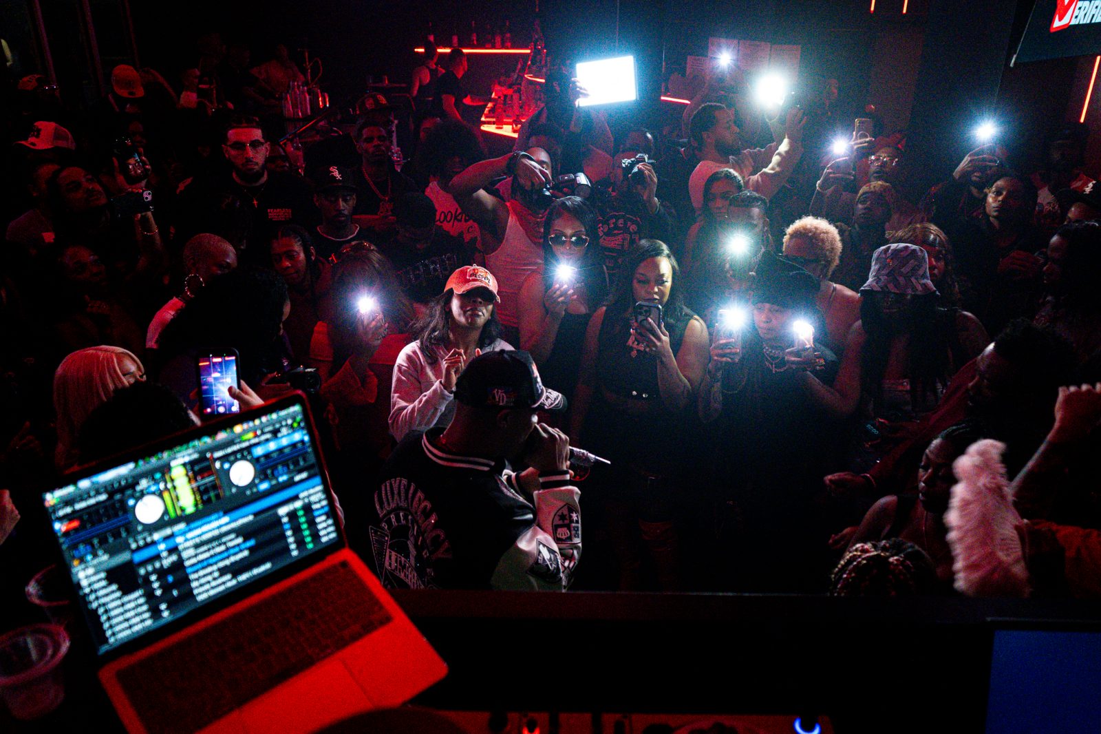 Crowd holding phone lights up at a packed venue