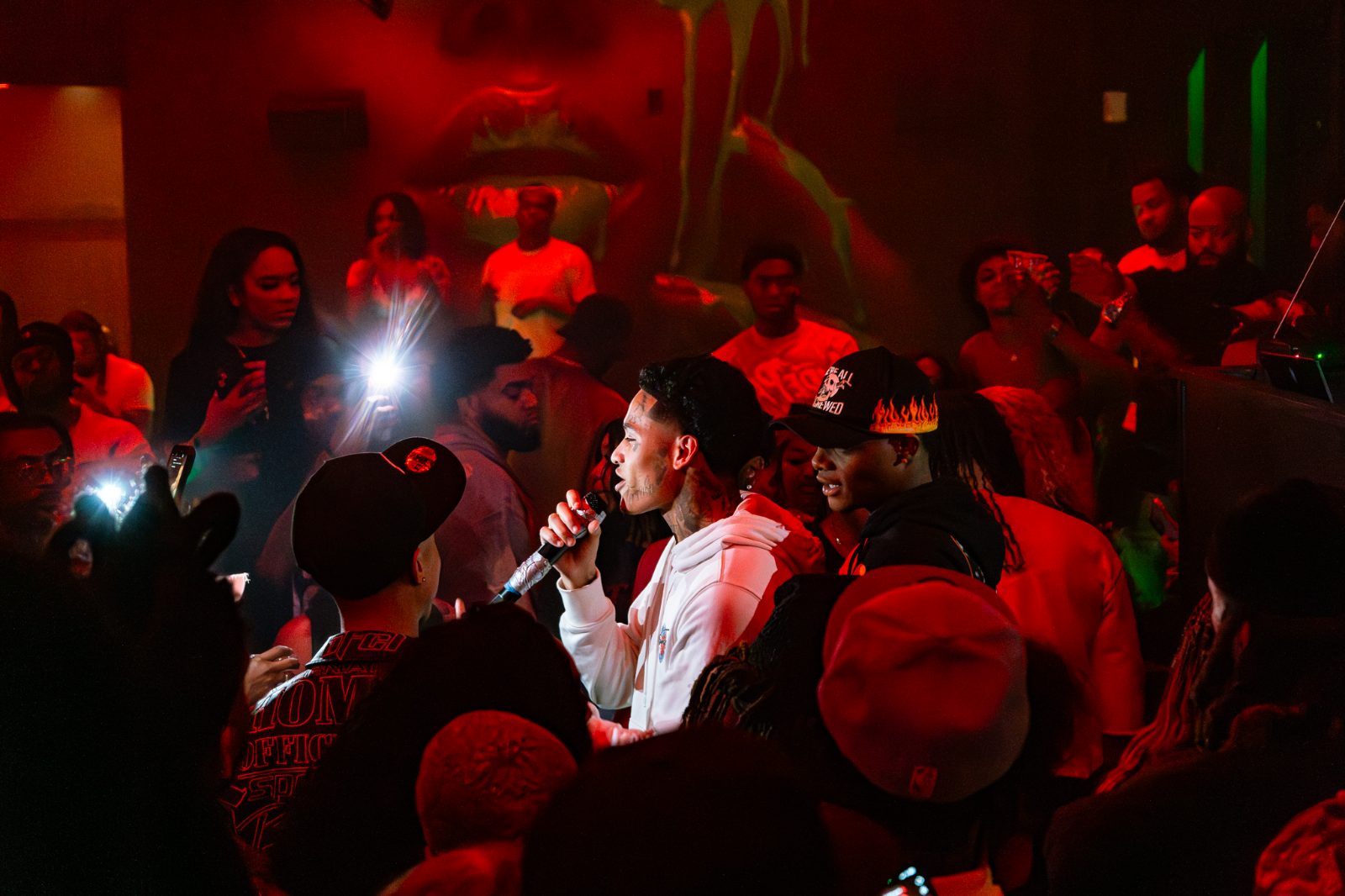 Crowd holding phone lights up at a packed venue
