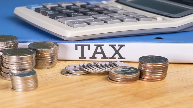 Calculatrice, pièces de monnaie et porte-document avec le mot tax