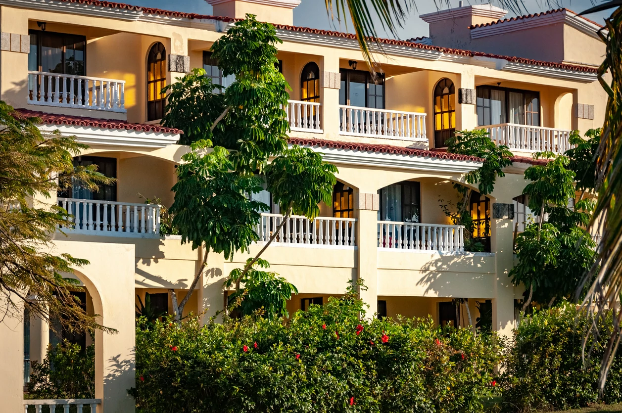 Grande maison avec des balcons et des arbres.