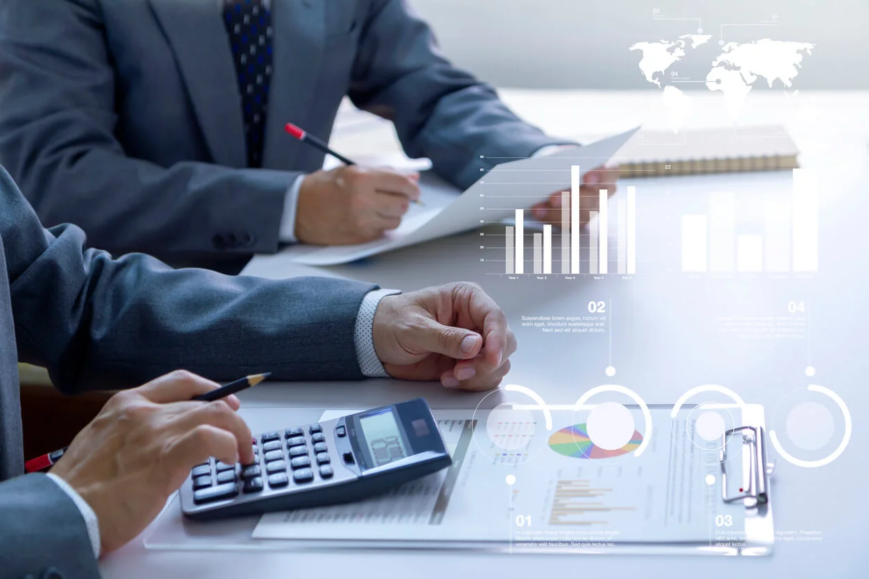 Homme utilisant une calculatrice à côté d'un autre homme consultant un document.