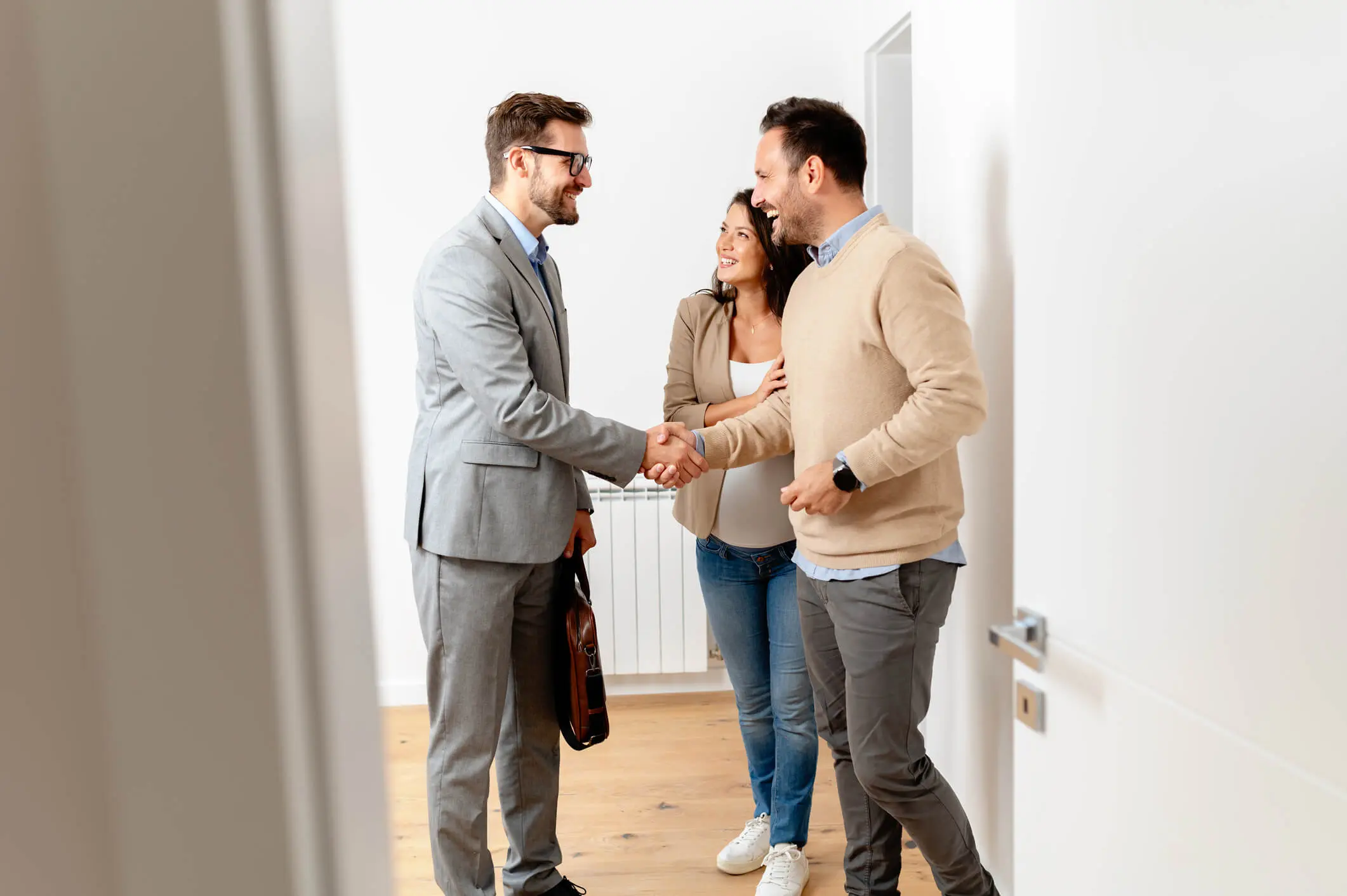 Professionnel immobilier serrant la main de l'homme à côté de sa femme.