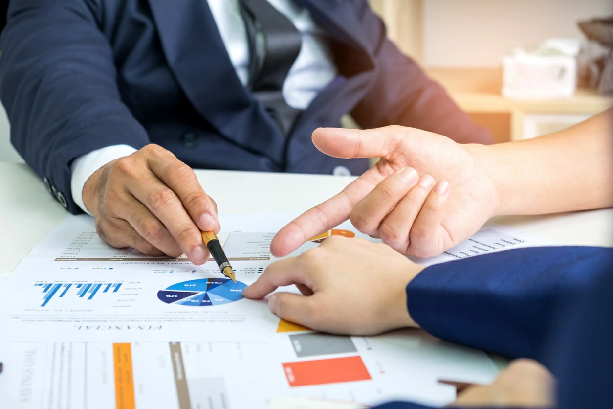 Deux professionnels consultant des documents avec graphique.