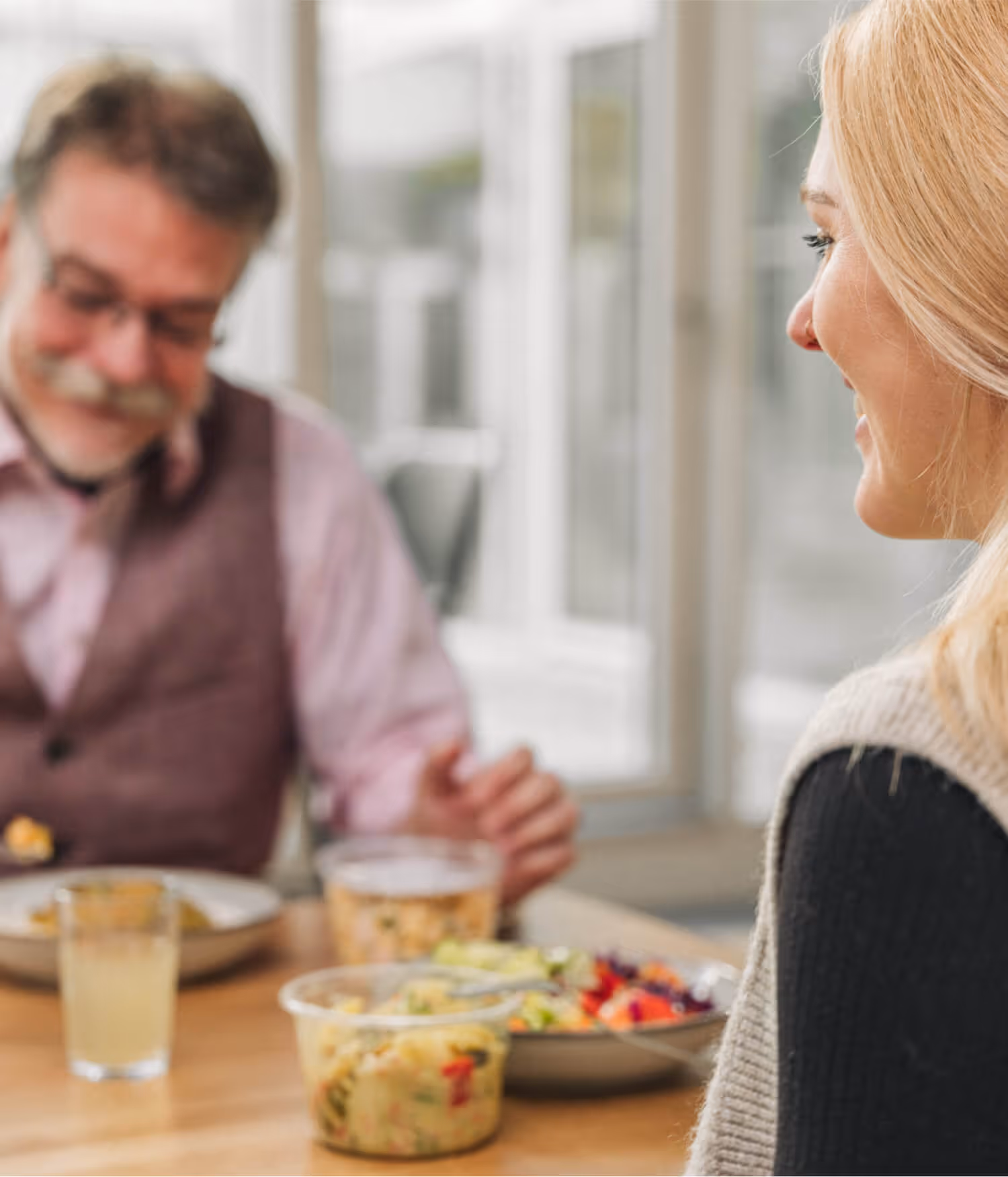 Eine Frau und ein Mann sitzen gemeinsam am Tisch und Essen zu Mittag.