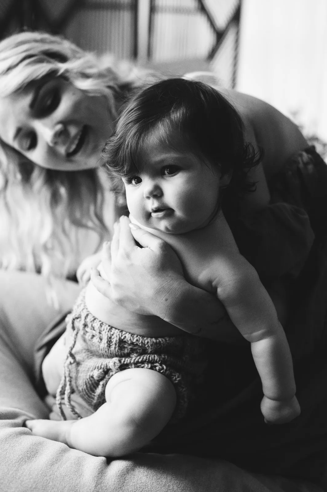 Sessione mamma e figlio in bianco e nero: la mamma sostiene il mento del bebè che guarda l'obiettivo