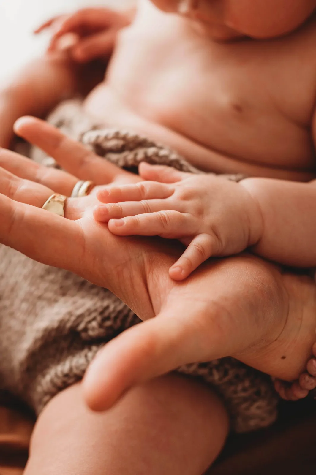 Dettaglio mom & me: la manina del bebè appoggiata sul palmo della mamma
