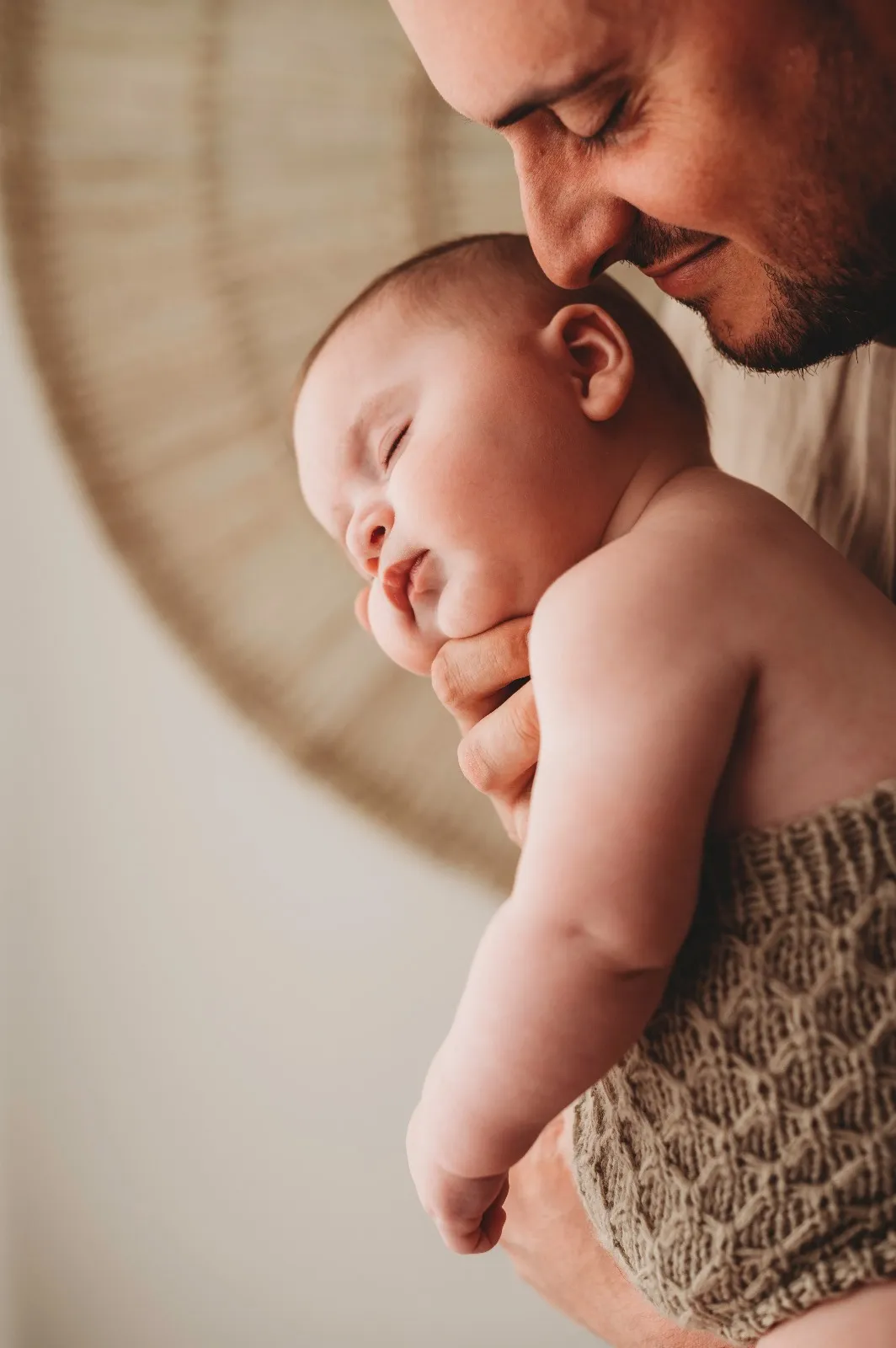 Sessione bebè in studio: papà con il bimbo addormentato appoggiato alla sua spalla