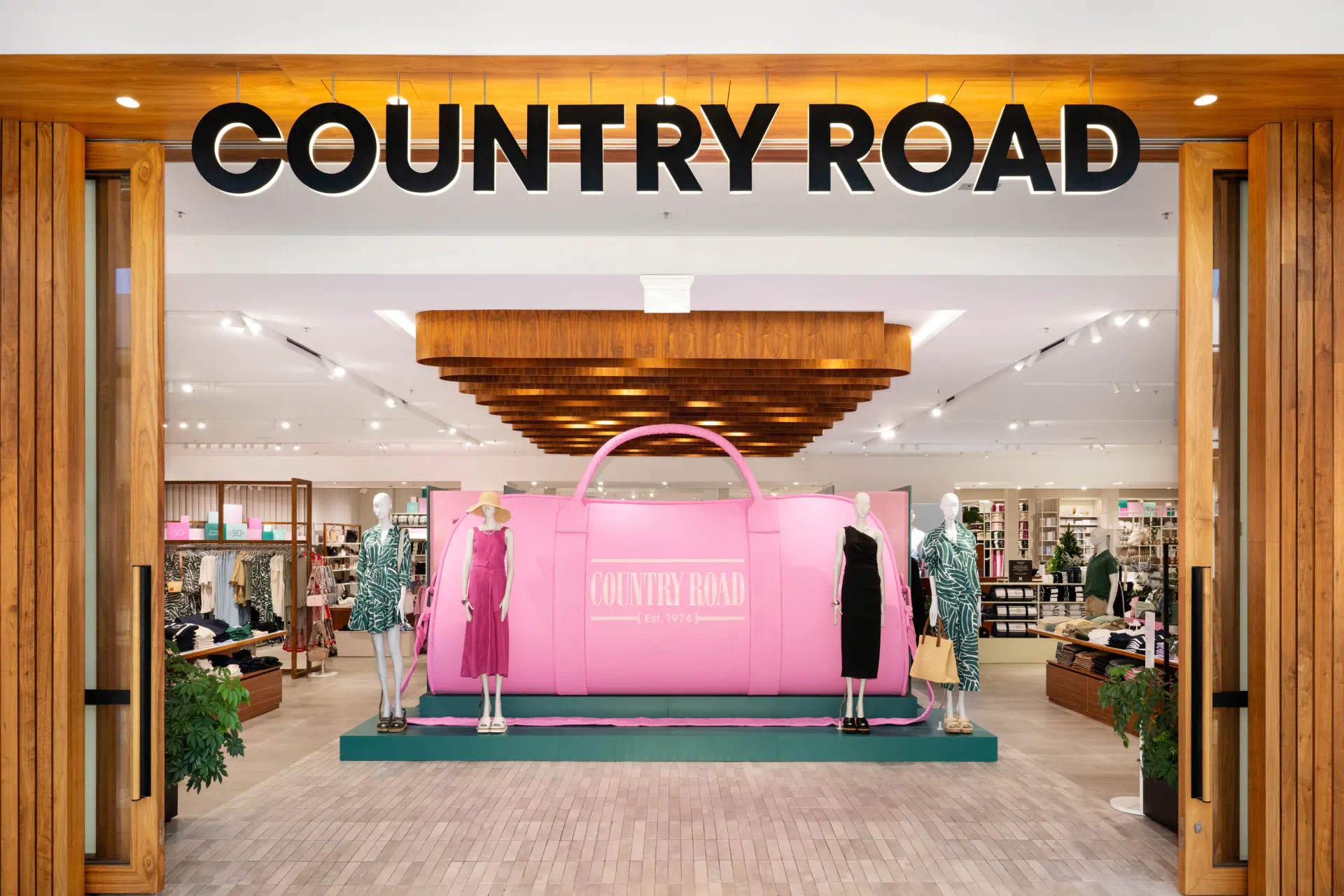 a store with mannequins and a large pink bag