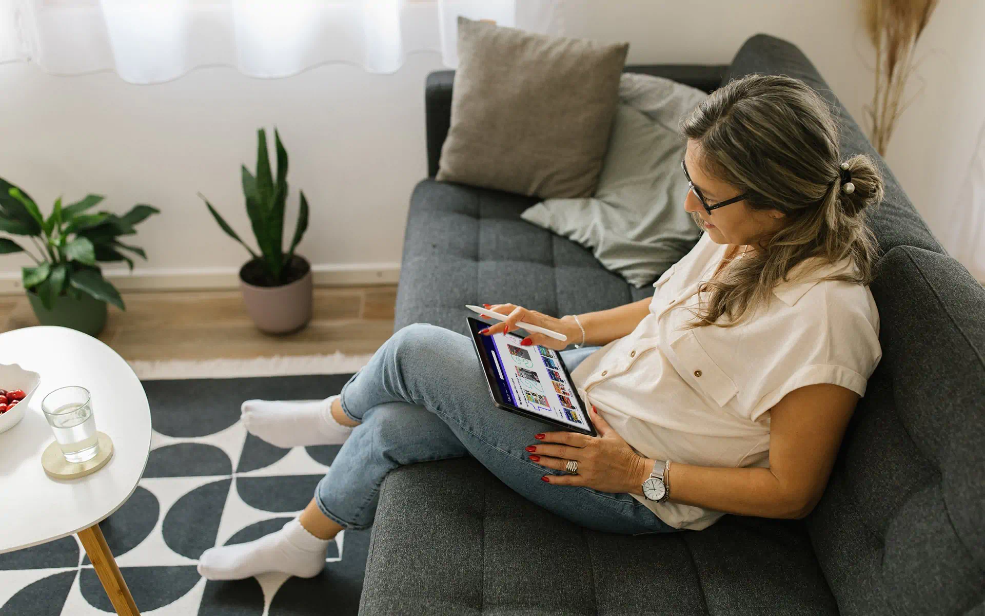 a woman sitting on a couch using a tablet