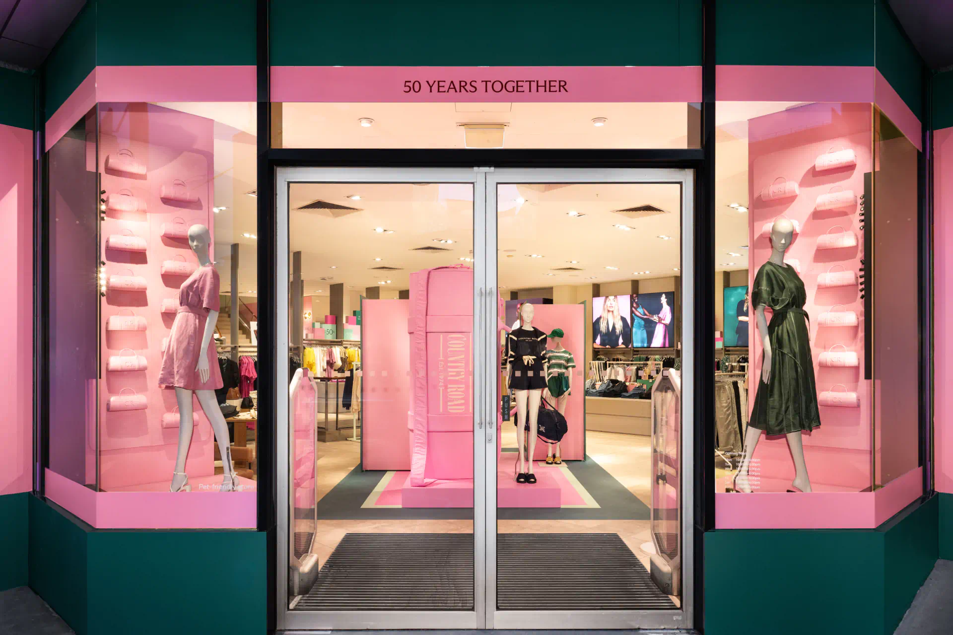 a store front with pink and green display windows