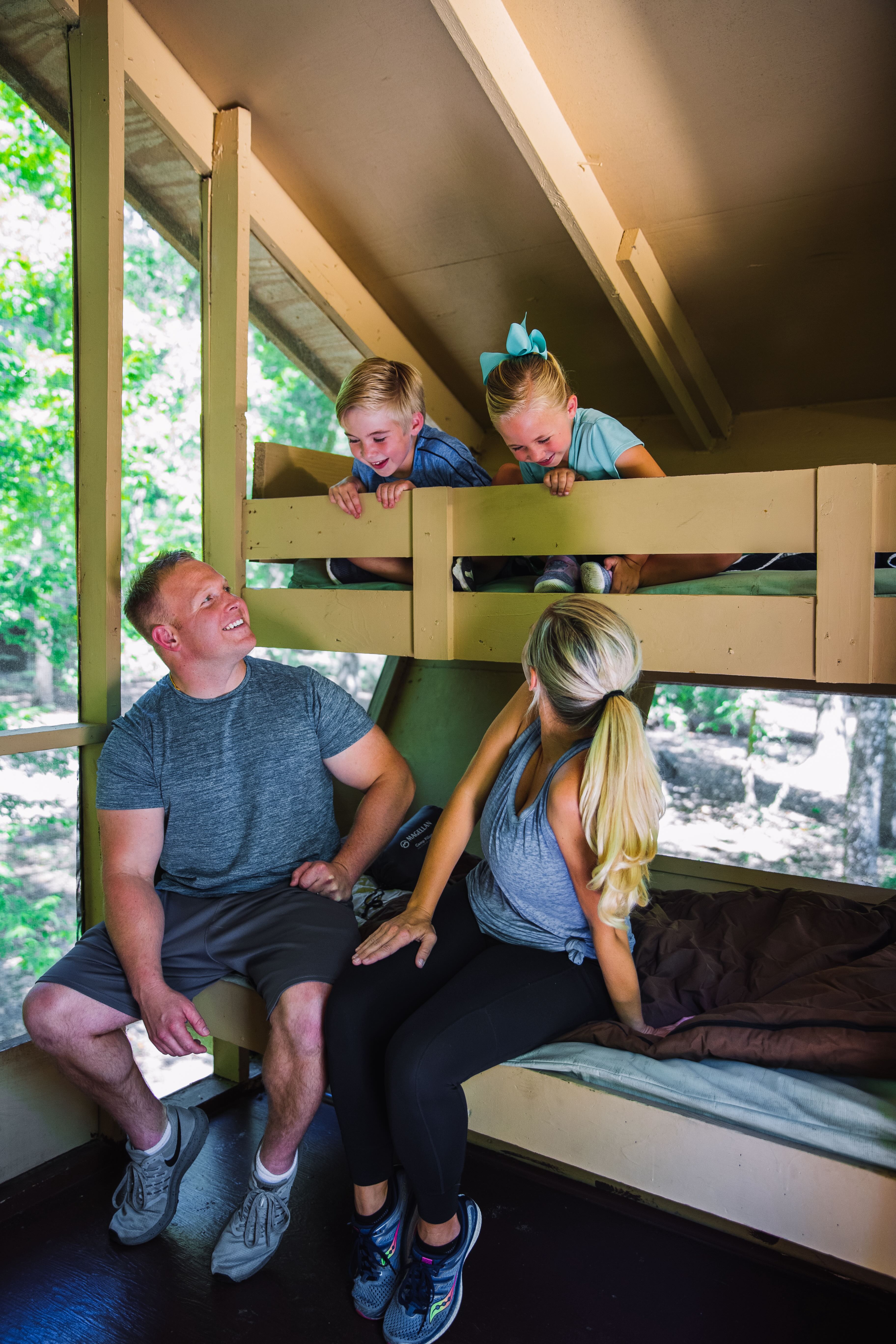 A man and a woman are sitting on bunk beds