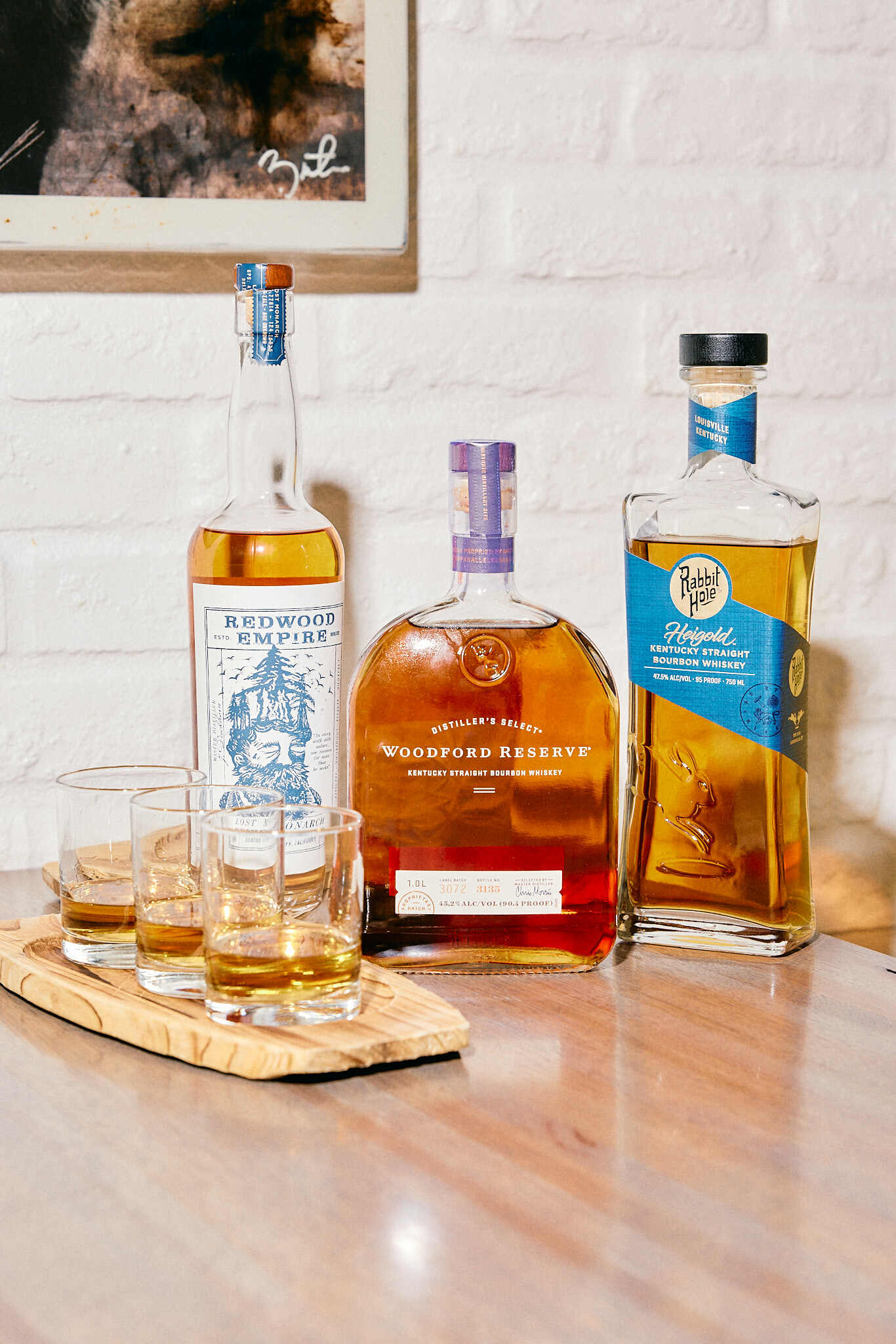 A wooden table topped with bottles of alcohol