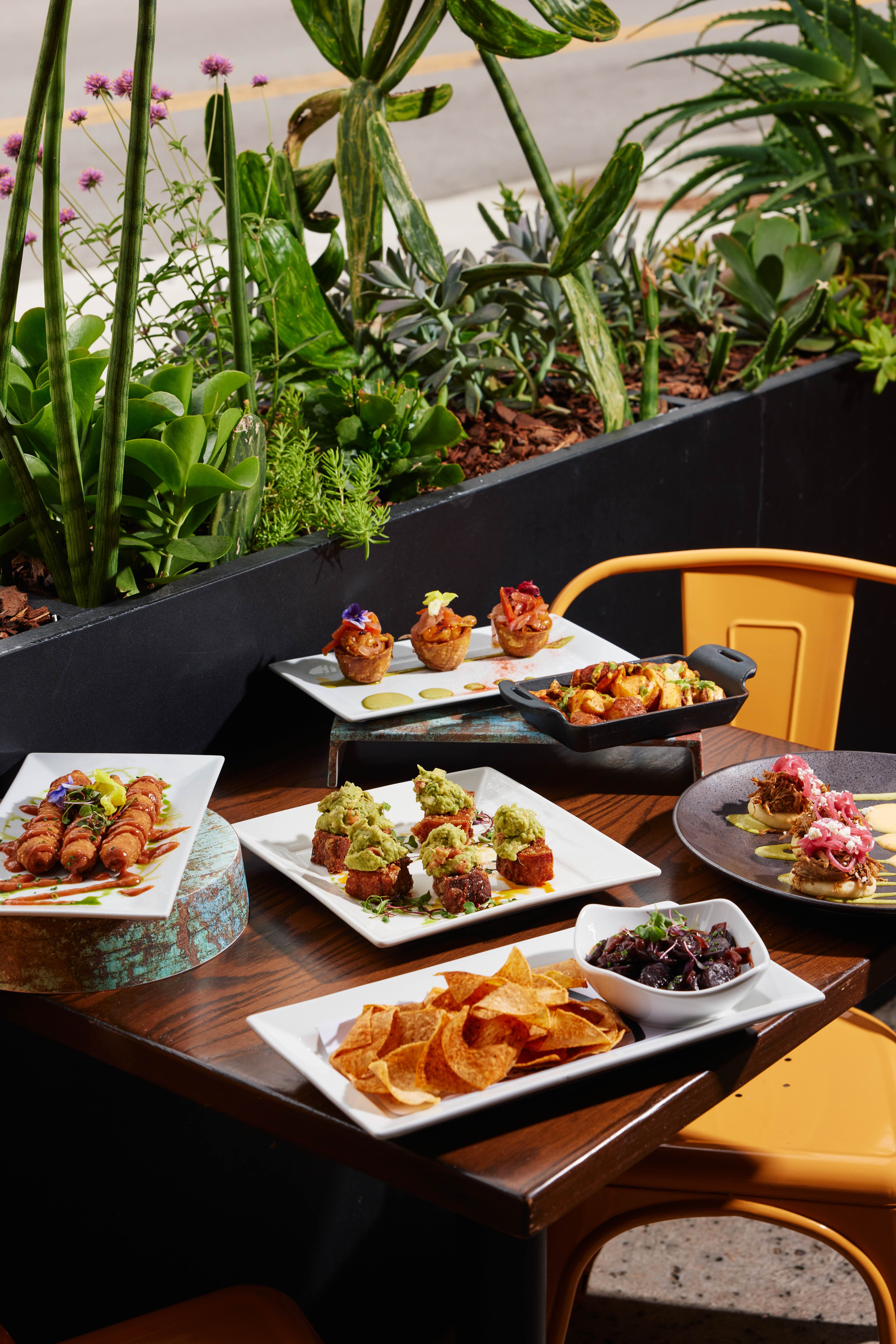 A wooden table topped with plates of food