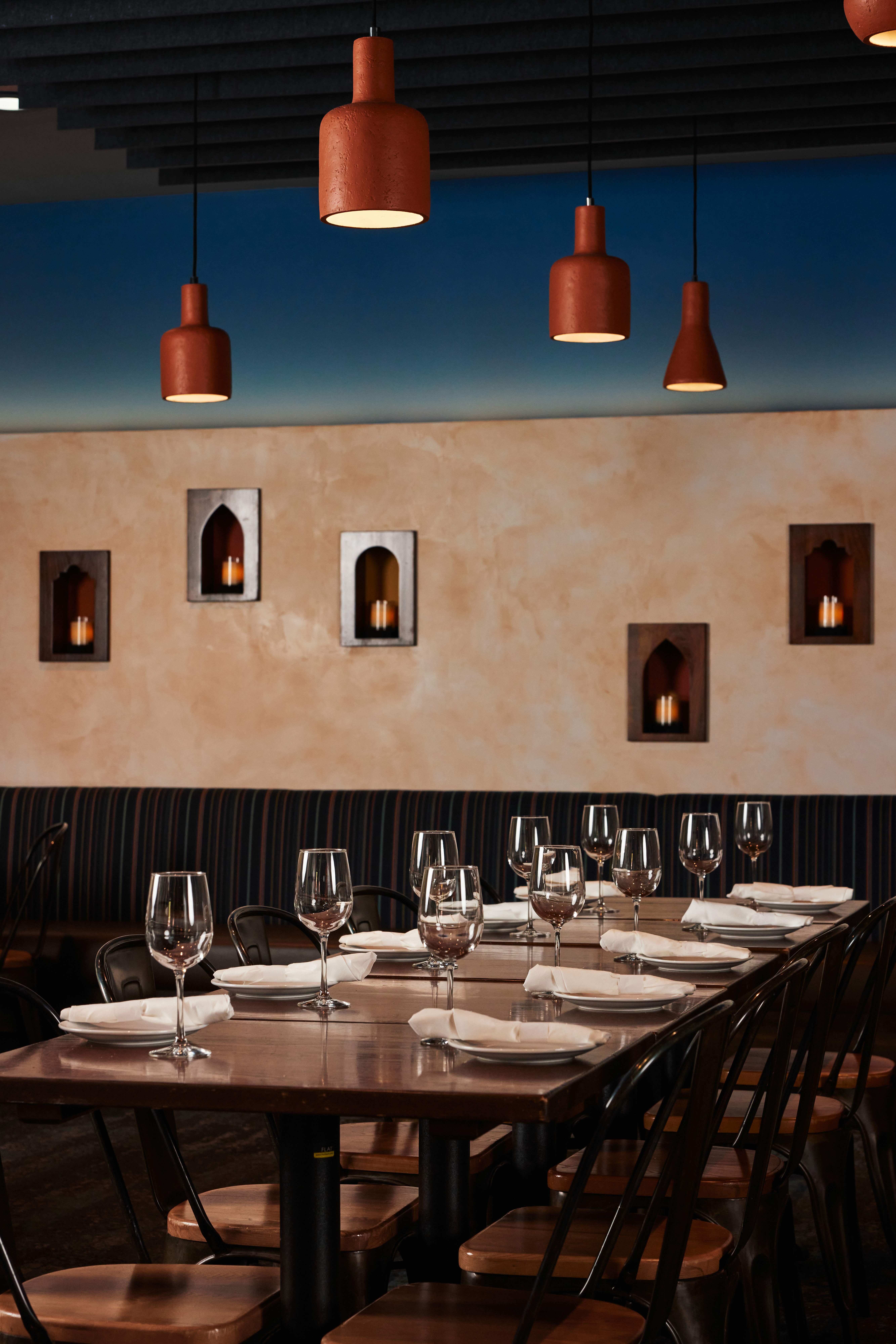 A long table with a bunch of wine glasses on it