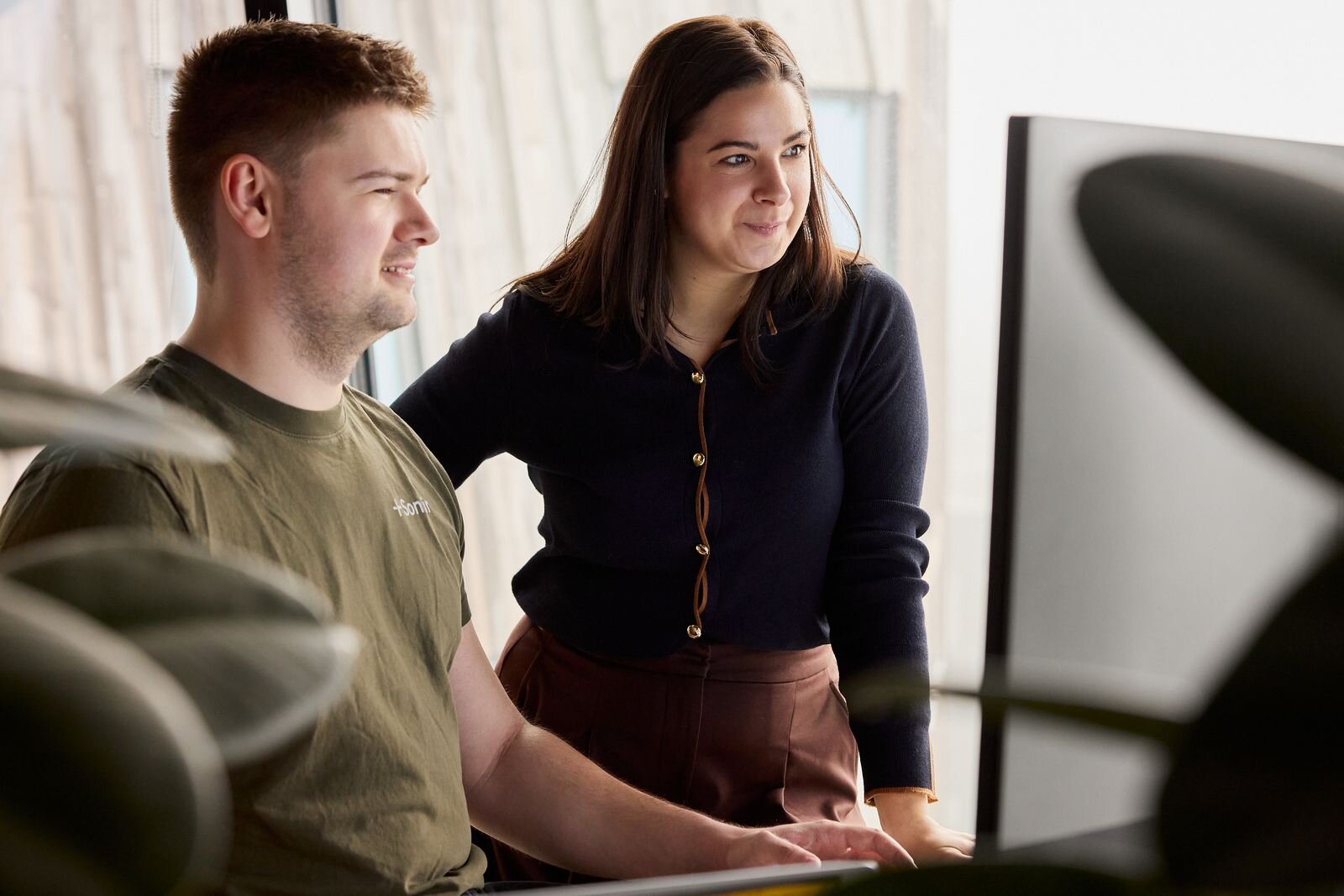 A woman at Sonair using a large monitor displaying scatter plots.