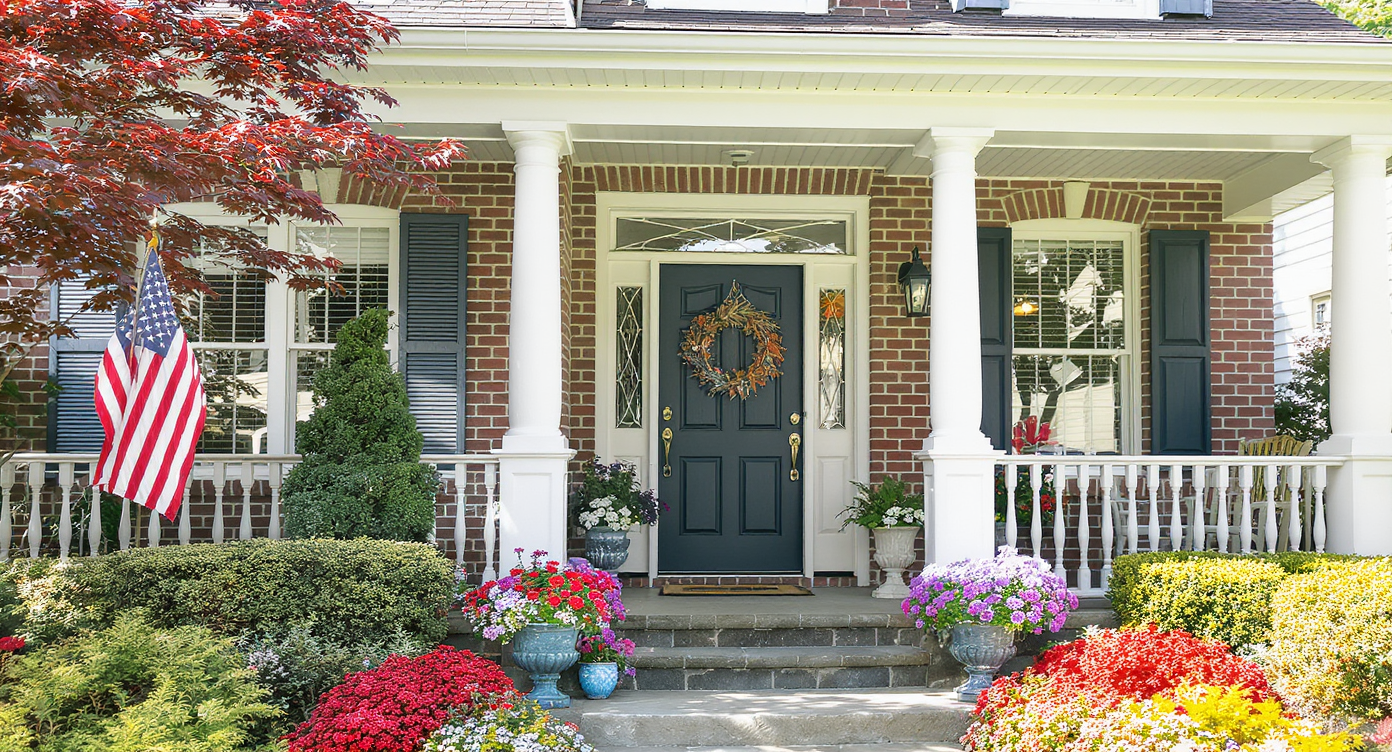 A beautifully landscaped home exterior showcasing vibrant flowers and an inviting front porch.