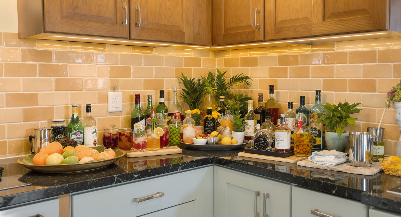 Elegant home bar setup in a vibrant kitchen with cocktails and stylish bar tools.