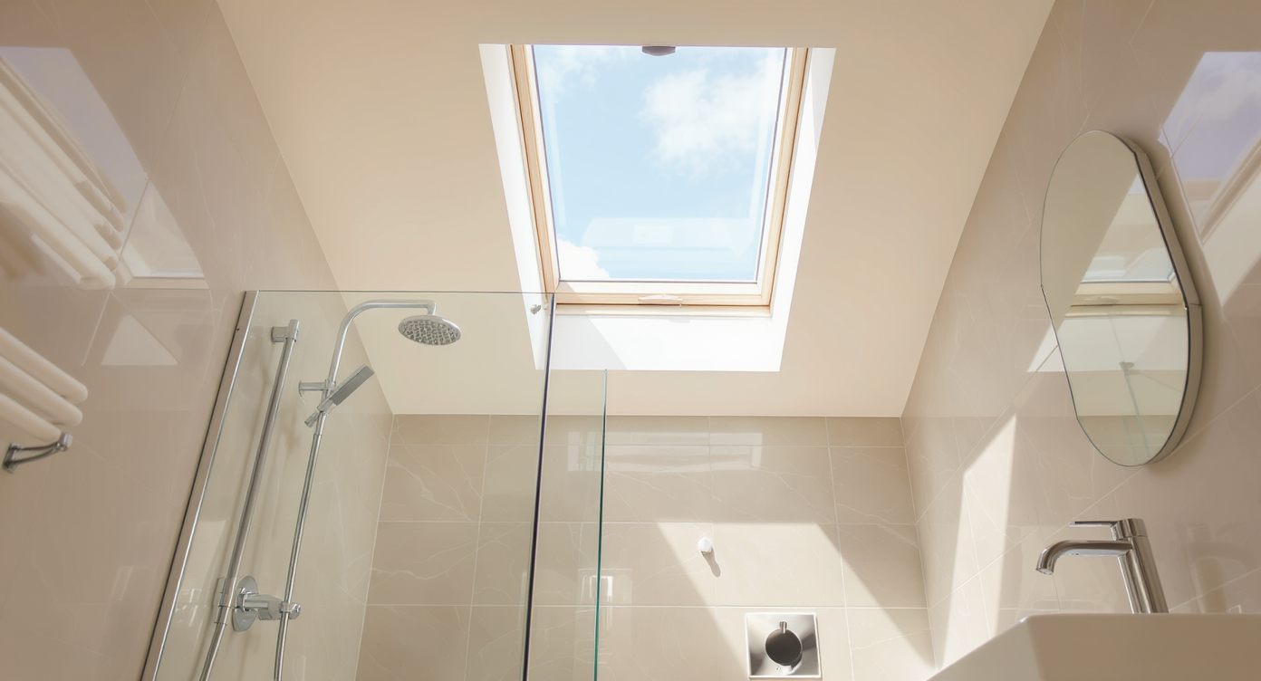 Small bathroom with skylight providing natural light, emphasizing glass shower and floating vanity in the design.