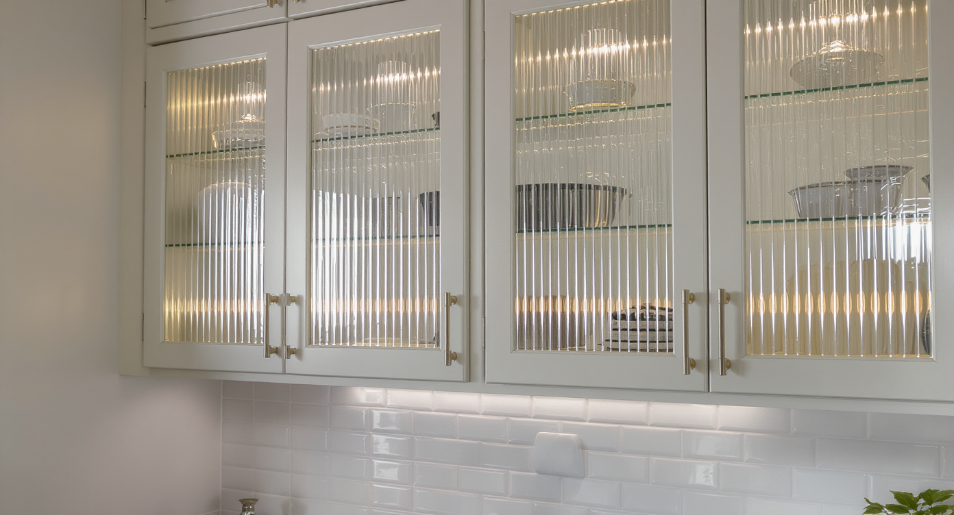 A kitchen with textured fluted glass cabinetry, adding visual interest and soft reflections to the design.