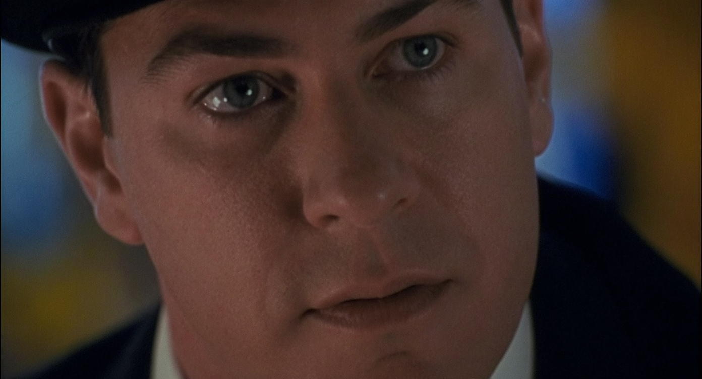 A historic kitchen combines beadboard walls, original wood windows, gingerbread trim, built-in shelves, and modern appliances in a bright, welcoming space.