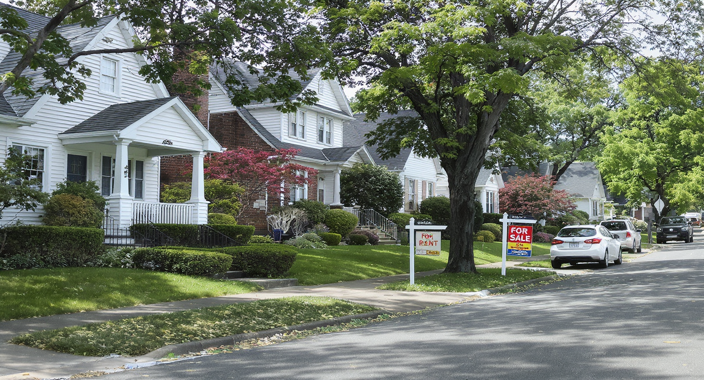 Suburban American street with varying house conditions, real estate signs, modern tech features, and no people, in natural daylight.