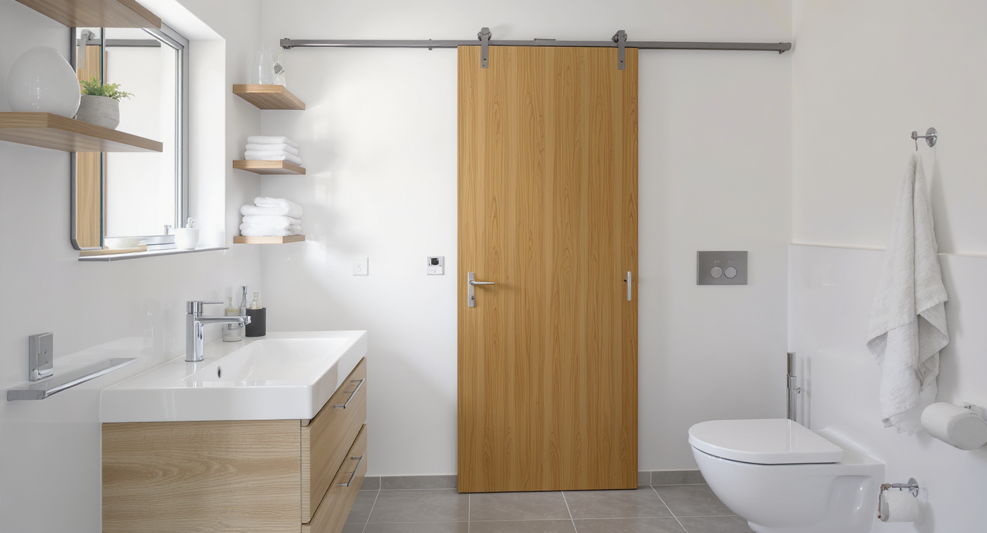 A compact modern bathroom with a pocket door recessed into the wall, maximizing space for fixtures and storage in a realistic, well-lit scene.