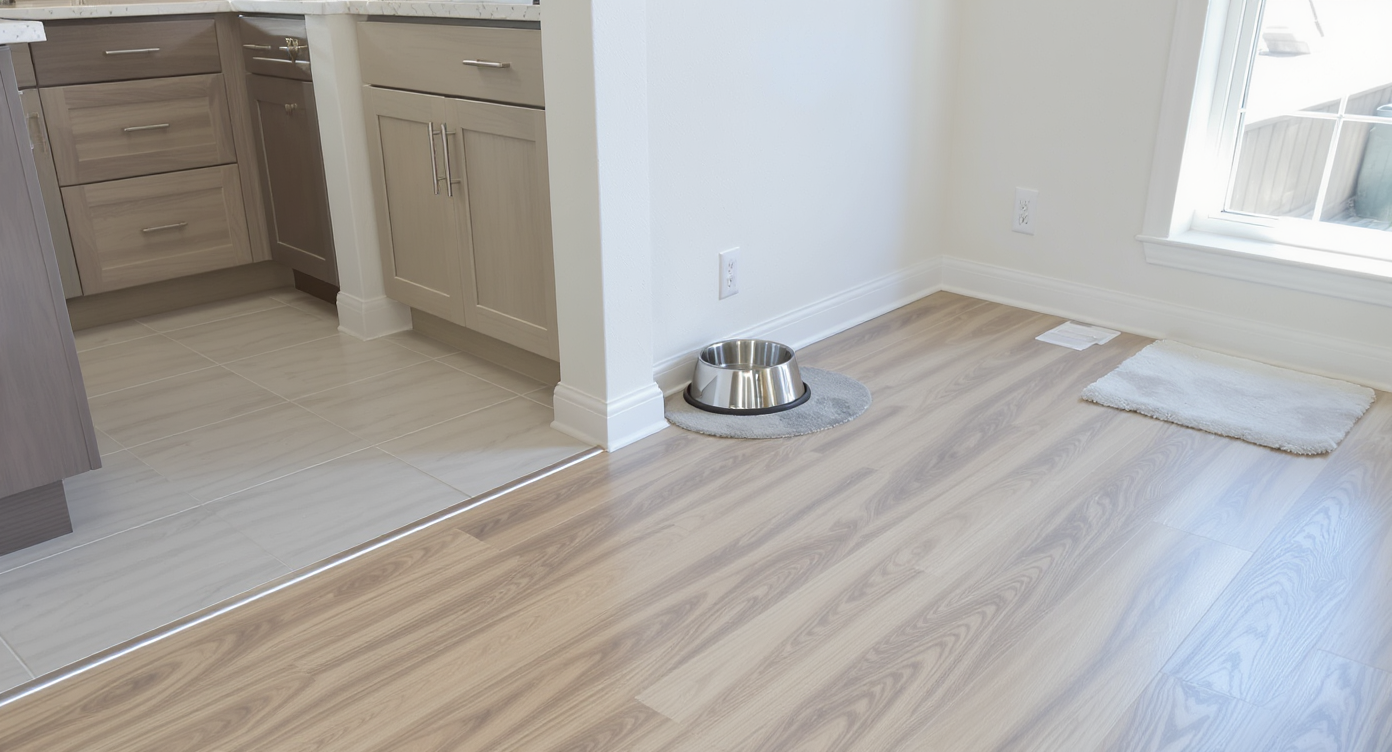 Modern townhouse interior with tile flooring in kitchen and bath areas, luxury vinyl plank in living space, pet water bowl near flooring transition.