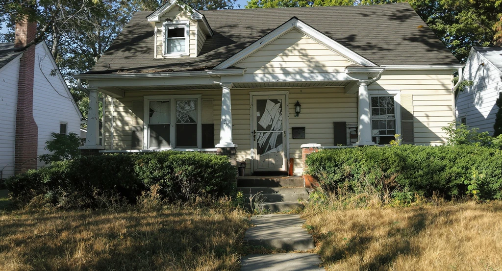 Unattractive house exterior with faded paint, overgrown landscaping, and outdated facade, showing how to make an ugly house exterior cute with affordable curb appeal makeover ideas and best exterior color combinations for resale.