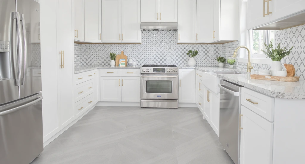 Wide view of a modern kitchen with a coordinated backsplash and floor pattern, hardware samples, and a tablet showing digital mockups for redesign ideas. How to visualize kitchen redesign ideas for people who can’t imagine spaces and tools for visualizing home décor changes.