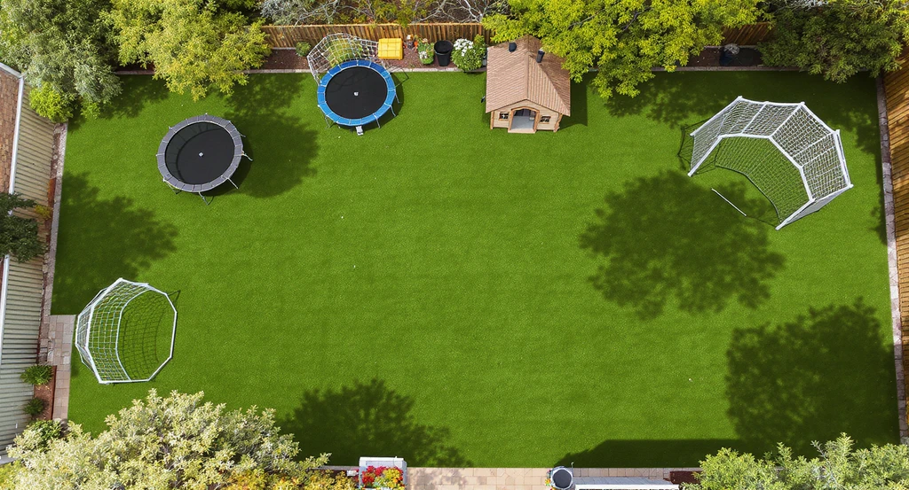 Overhead view of a backyard simulating different placements for a trampoline and cubby house, showing clear soccer space and realistic shadows. Backyard layout ideas with play equipment and best trampoline and cubby house placement tips for family-friendly design.
