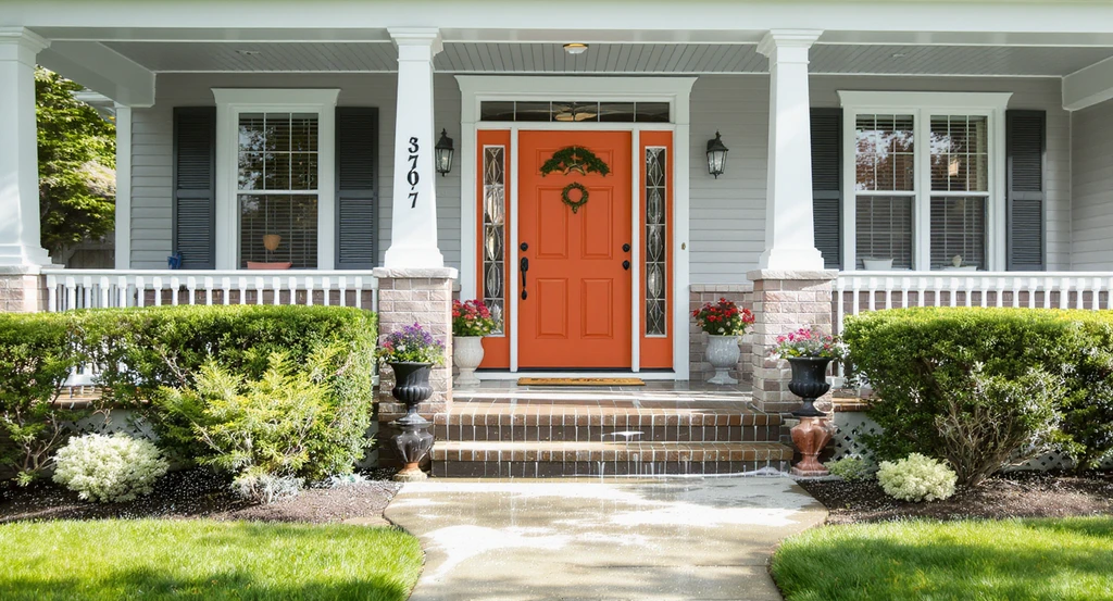 Curb appeal upgrades shown on a home entry: fresh paint, trimmed plants, power-washed walkway—demonstrating how AI enhances home staging impressions by visualizing improvements buyers notice first.