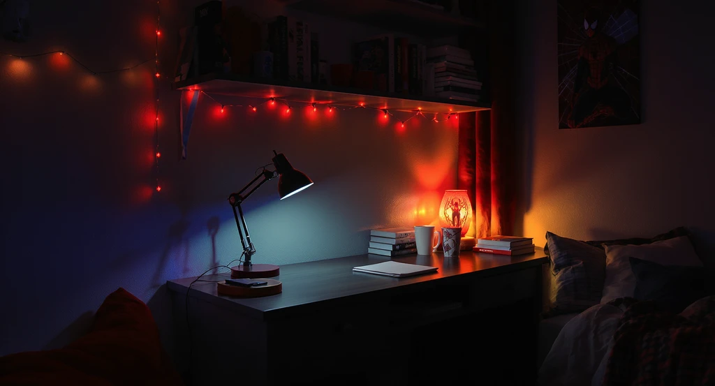 Modern college dorm room with Spider-Man desk lamp, red string lights, and nightlight, layered for late-night study; ai virtual staging for dorm rooms, showcasing how to design themed dorms with ai and ai room makeover ideas for small spaces.