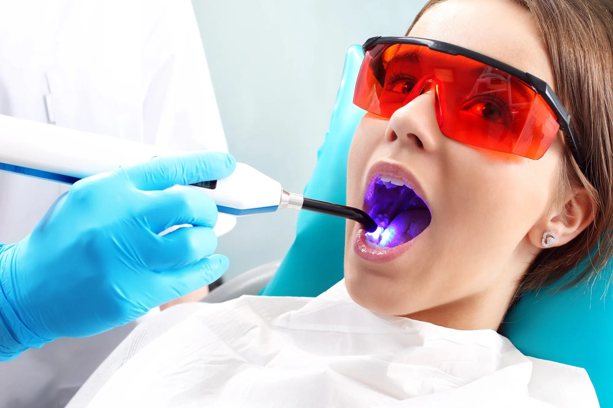 Emergency dentist in Lexington using a curing light during a patient’s dental treatment