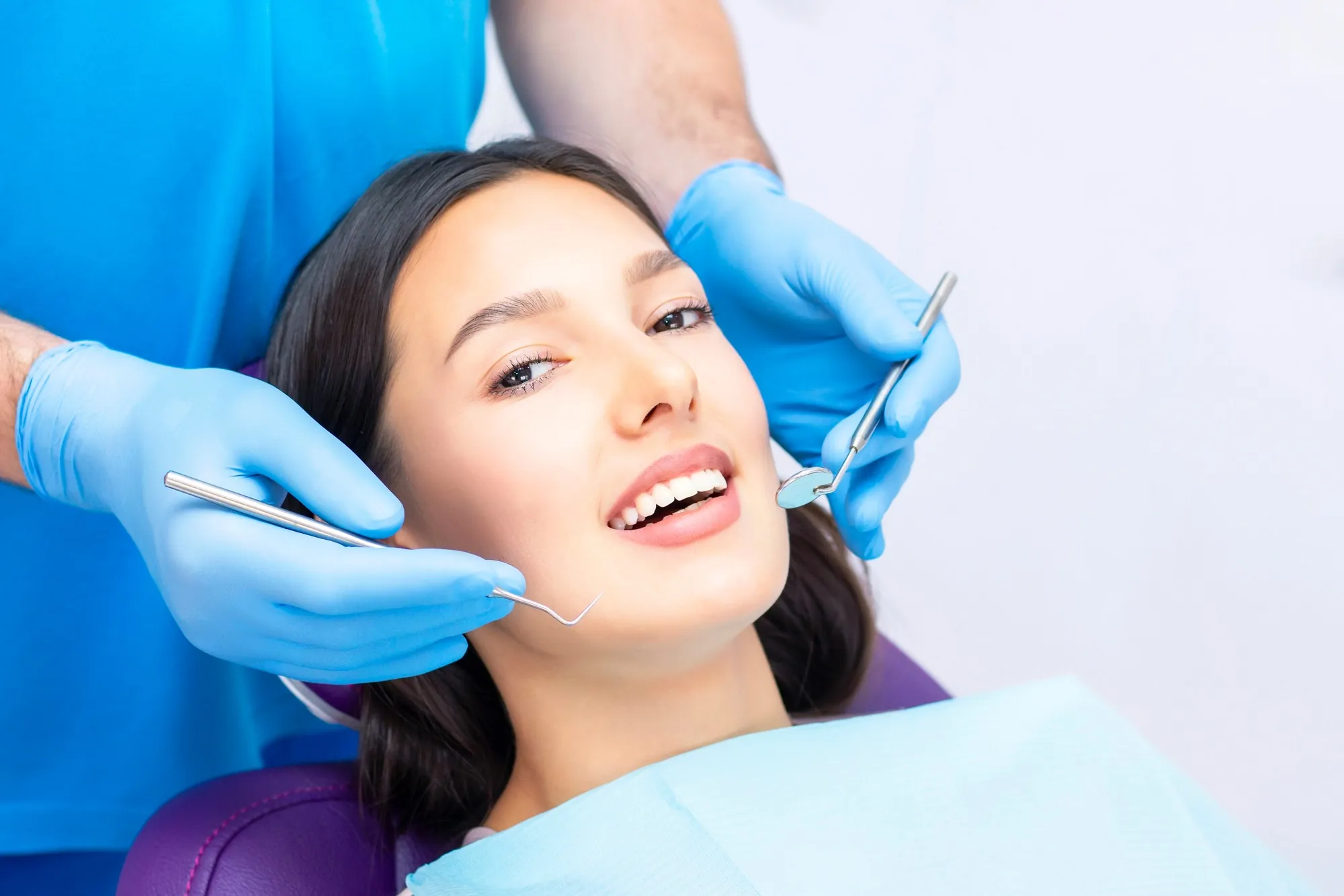 Dentist examining a smiling patient during a same day dentures consultation in Lexington KY